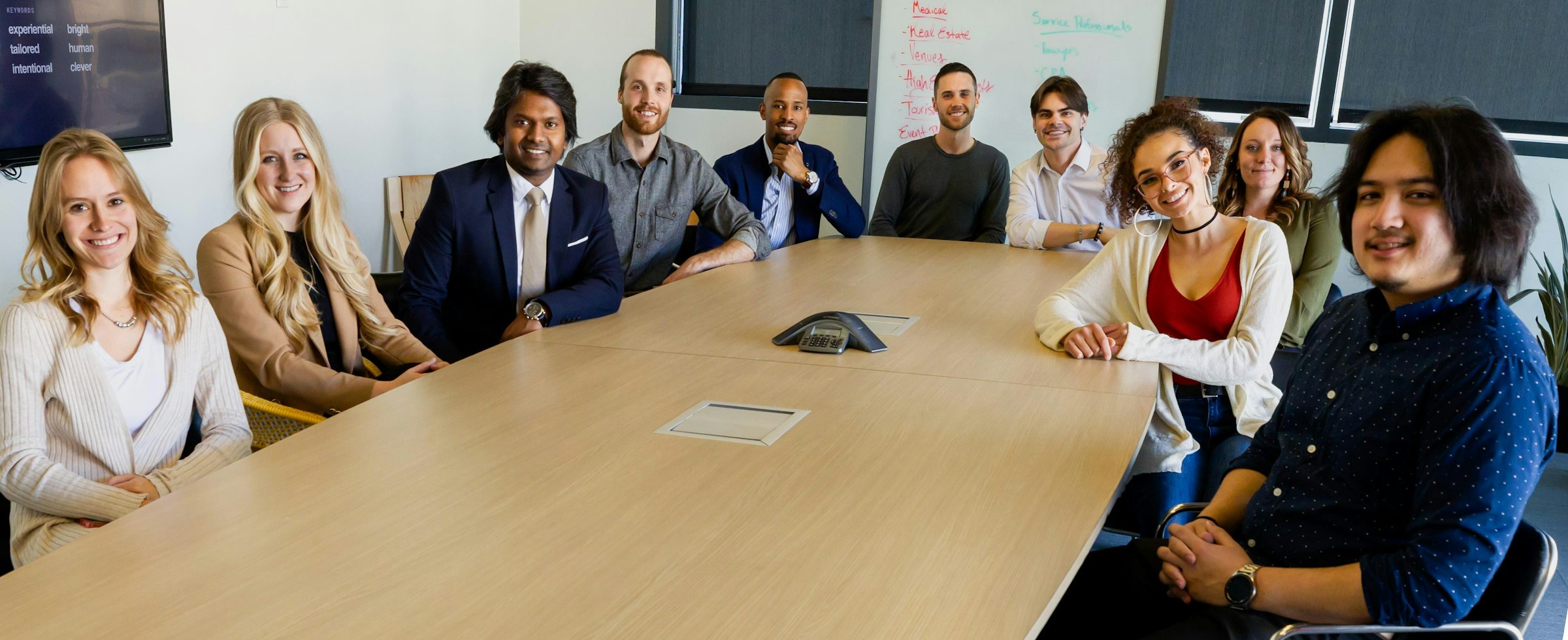 Diverse team of men and women smiling around a conference table